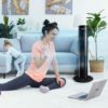 Fitness woman exercising on the floor at home and watching fitness videos in a laptop. Young female trainer doing online fitness training for her clients.