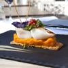 Saint-Jacques scallops, carrots puree and biscuit on a slate