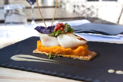 Saint-Jacques scallops, carrots puree and biscuit on a slate